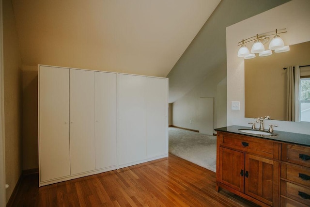 bathroom with vanity, lofted ceiling, and wood finished floors