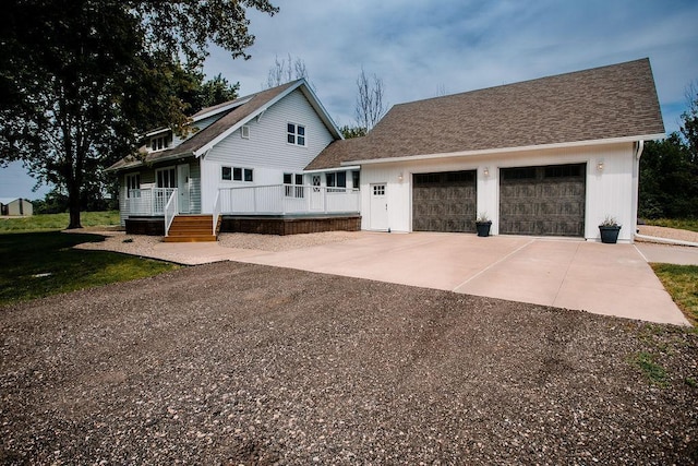 view of front facade with concrete driveway, an attached garage, a porch, and roof with shingles