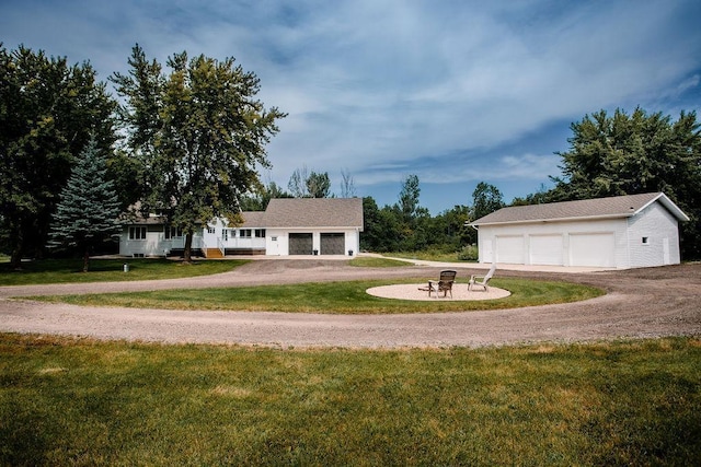 exterior space with a front lawn, an outbuilding, and a detached garage