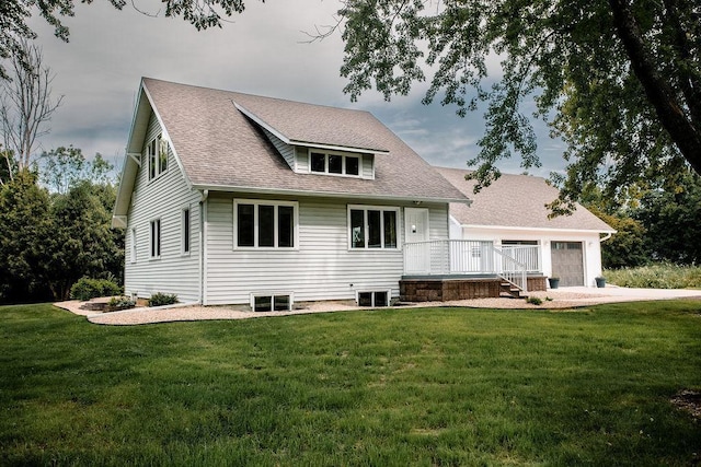 rear view of property featuring an attached garage, a yard, and roof with shingles