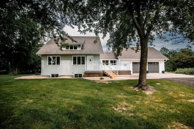 back of house featuring a lawn, a garage, and driveway