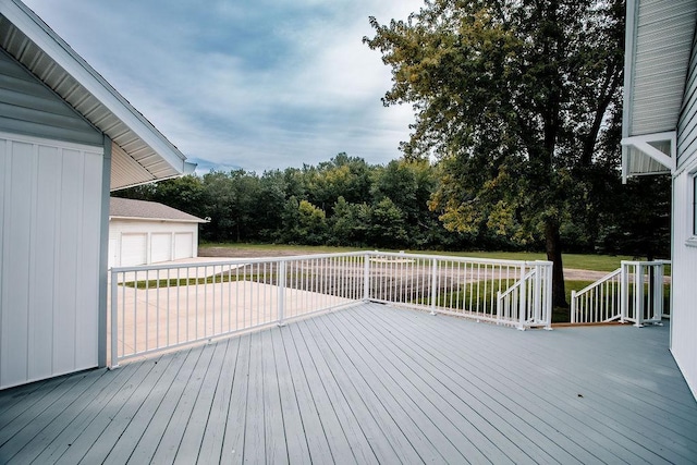 wooden deck featuring a garage and an outdoor structure