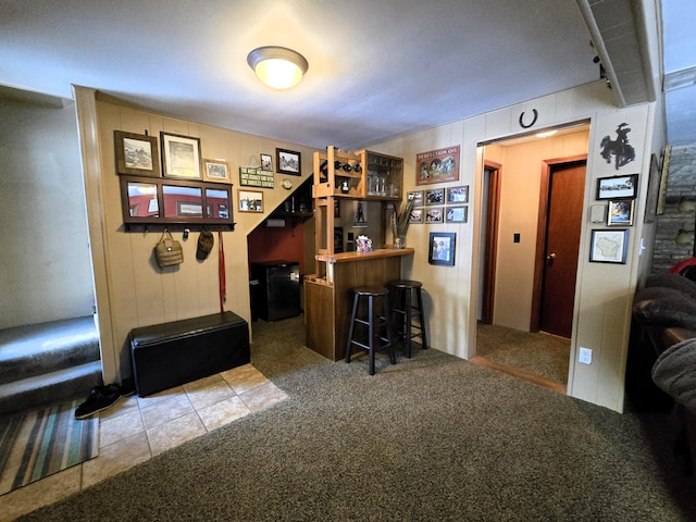 bar featuring a dry bar, carpet flooring, and tile patterned floors