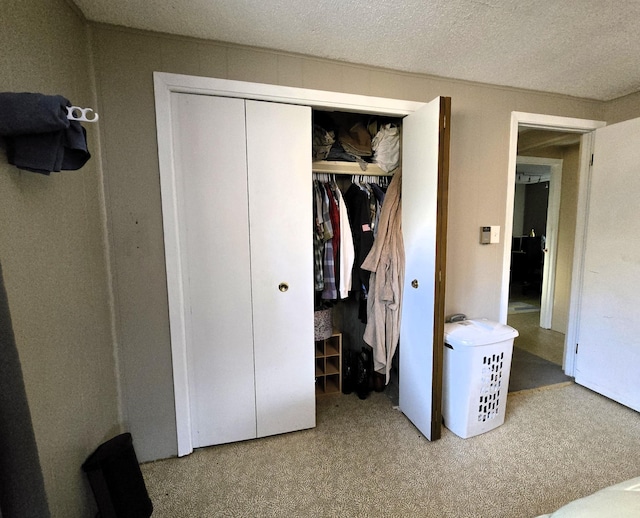 unfurnished bedroom with carpet floors, a closet, and a textured ceiling