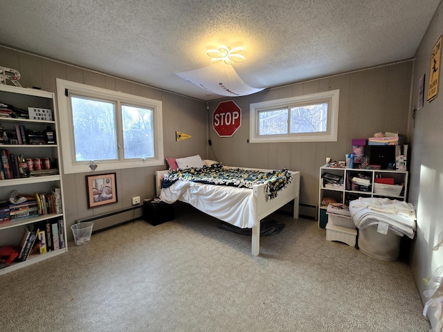 bedroom with a baseboard heating unit and a textured ceiling