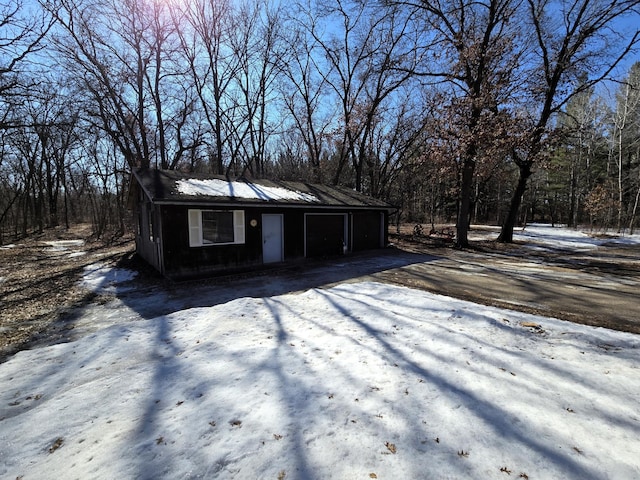 snow covered structure featuring driveway