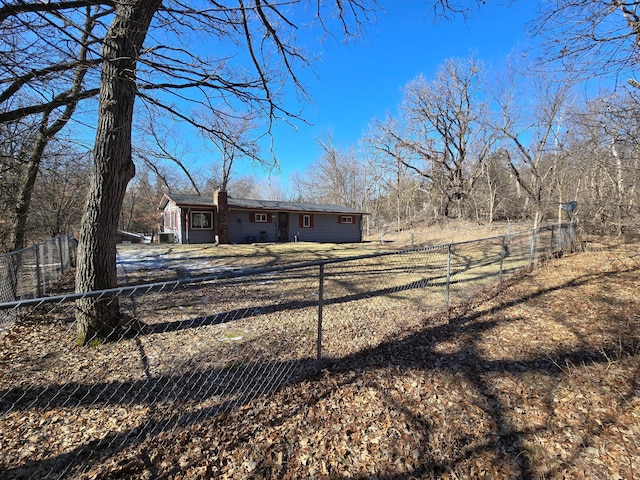 rear view of house featuring a chimney and a fenced backyard
