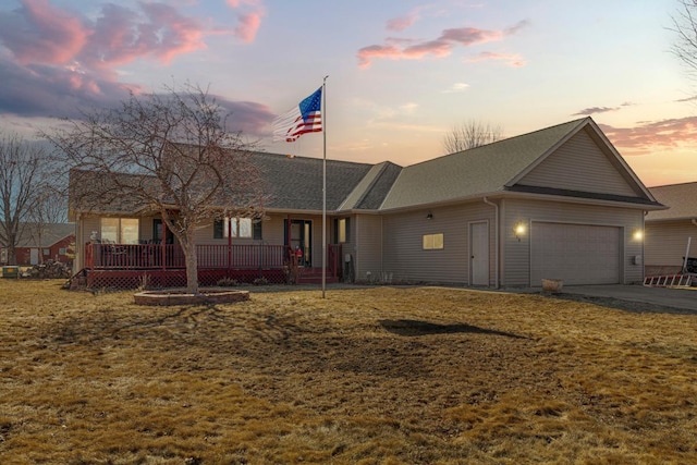 single story home with a yard, driveway, an attached garage, and a porch