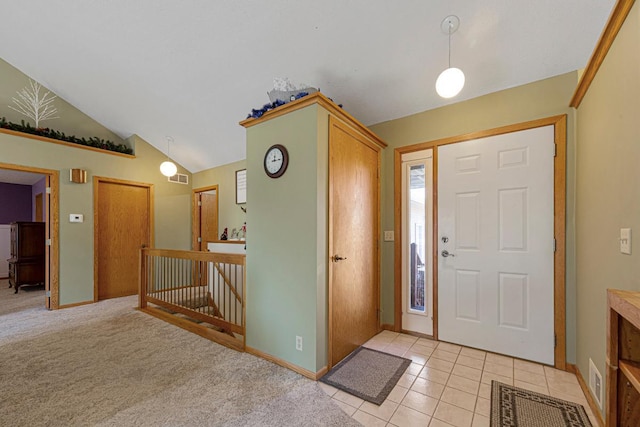 entryway with vaulted ceiling, light tile patterned flooring, visible vents, and baseboards