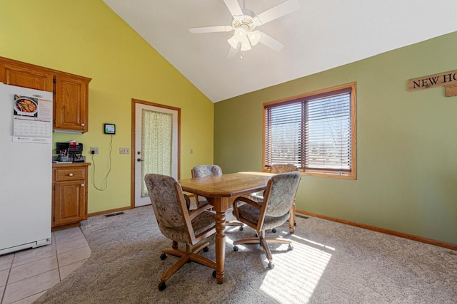 dining space featuring light carpet, light tile patterned floors, visible vents, baseboards, and ceiling fan