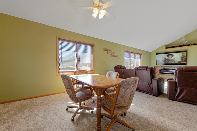 dining space featuring lofted ceiling, carpet, baseboards, and a ceiling fan