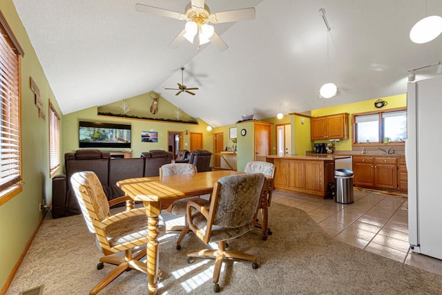 dining space with lofted ceiling, ceiling fan, light tile patterned flooring, light colored carpet, and visible vents