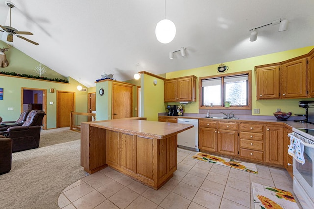 kitchen featuring light carpet, white appliances, lofted ceiling, open floor plan, and a sink