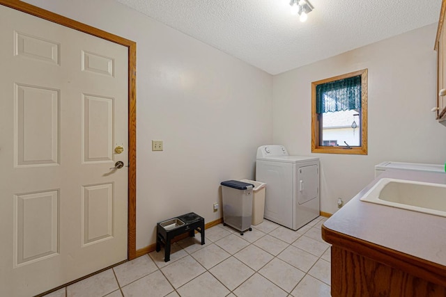 laundry room with cabinet space, a sink, a textured ceiling, and light tile patterned floors