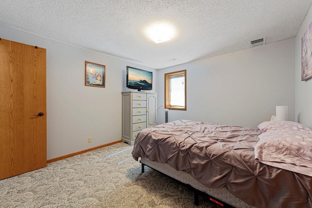 carpeted bedroom featuring baseboards, visible vents, and a textured ceiling