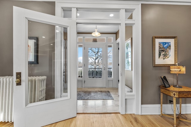 entrance foyer with baseboards, wood finished floors, and radiator heating unit