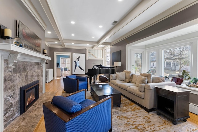 living room with visible vents, recessed lighting, a fireplace, and light wood-style floors