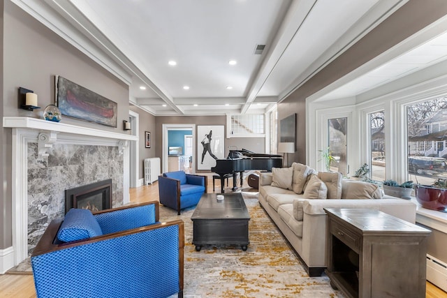 living area with a tiled fireplace, radiator heating unit, baseboard heating, recessed lighting, and wood finished floors