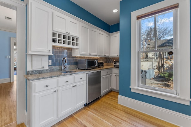 kitchen featuring visible vents, stainless steel appliances, light wood-style floors, and a sink