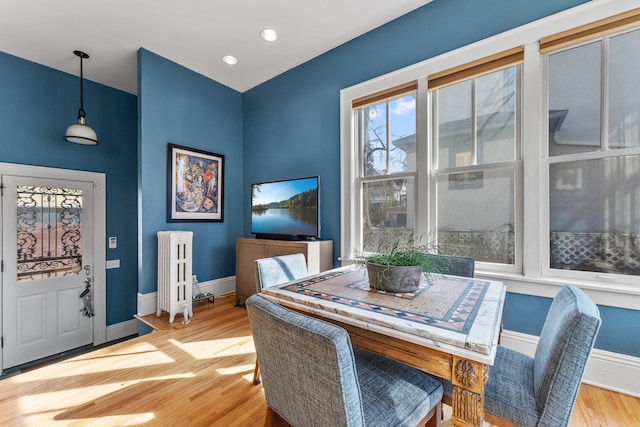 dining space featuring recessed lighting, baseboards, radiator, and wood finished floors