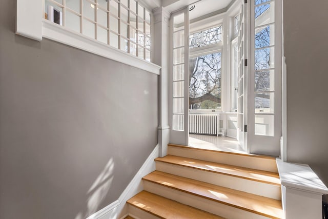 stairway with baseboards and radiator