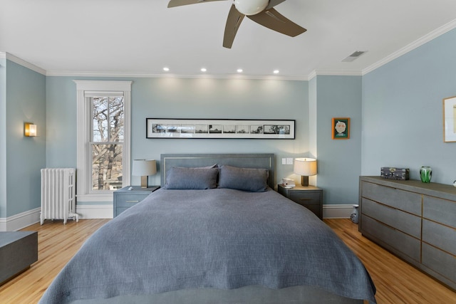 bedroom featuring baseboards, radiator, wood finished floors, and ornamental molding