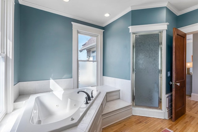 bathroom with crown molding, wood finished floors, a stall shower, and a whirlpool tub