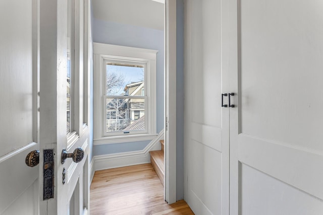 entryway with light wood finished floors and baseboards