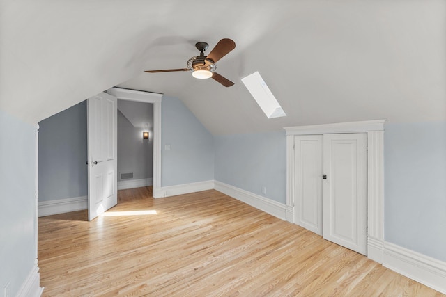 bonus room with vaulted ceiling with skylight, visible vents, light wood-style flooring, and a ceiling fan