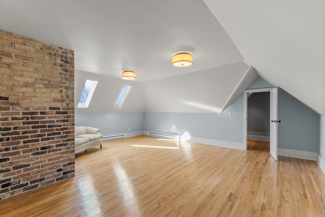 bonus room featuring a baseboard heating unit, vaulted ceiling with skylight, wood finished floors, and baseboards