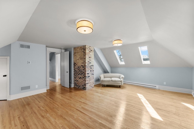 bonus room with visible vents, vaulted ceiling with skylight, a baseboard heating unit, and wood finished floors