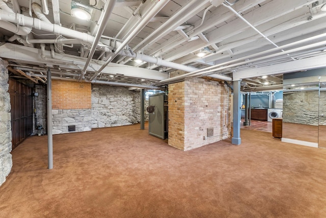 unfinished basement with washer / dryer and carpet flooring