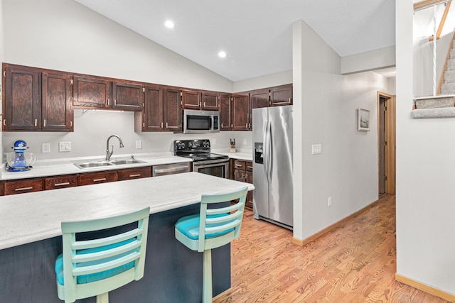 kitchen featuring light countertops, light wood-type flooring, appliances with stainless steel finishes, and a sink