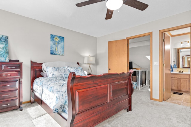 bedroom with light colored carpet, ensuite bathroom, and baseboards