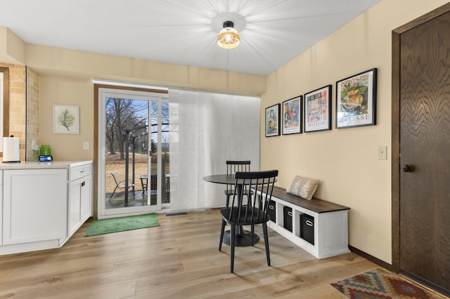 dining space with light wood-style floors and baseboards