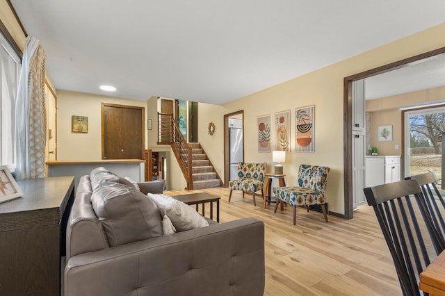 living room with light wood-style flooring and stairway