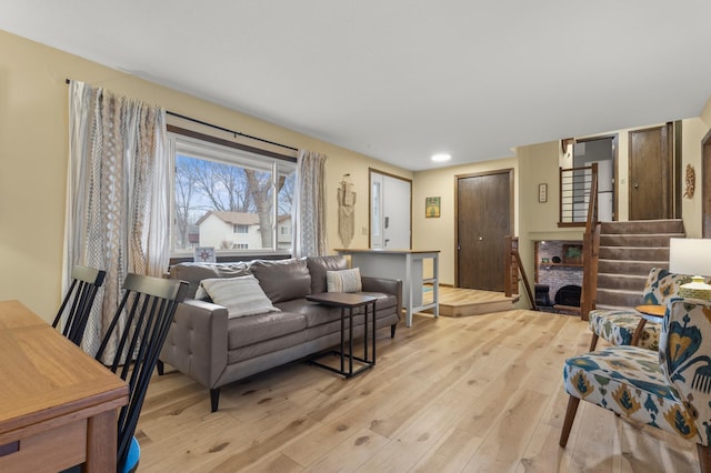 living area with light wood finished floors and stairway