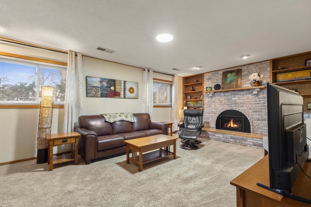 living room featuring built in shelves, carpet, a fireplace, and visible vents