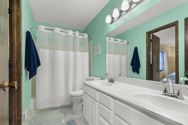 full bathroom featuring double vanity, a sink, toilet, and tile patterned floors