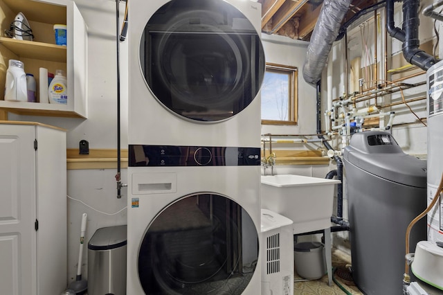 laundry room with laundry area, stacked washing maching and dryer, and a sink