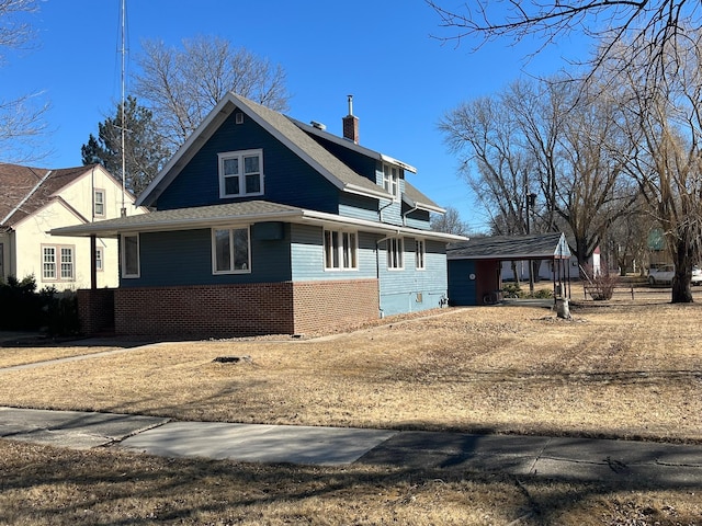 view of front of property featuring brick siding and a chimney