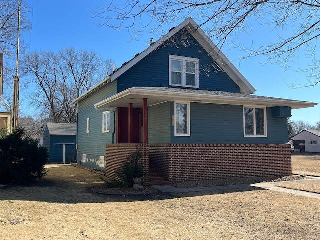 view of front facade with brick siding and a front yard