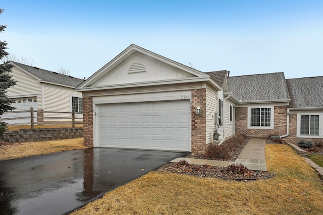 ranch-style house with aphalt driveway, brick siding, a front yard, fence, and a garage