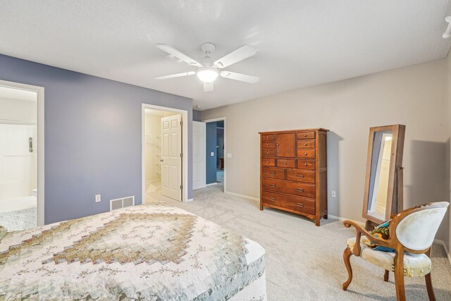 bedroom featuring connected bathroom, light carpet, a ceiling fan, visible vents, and baseboards