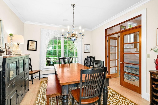 dining area featuring light wood-style floors, baseboard heating, crown molding, and an inviting chandelier