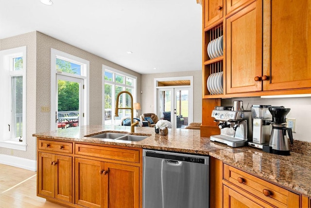 kitchen featuring a peninsula, a sink, stainless steel dishwasher, brown cabinets, and open shelves