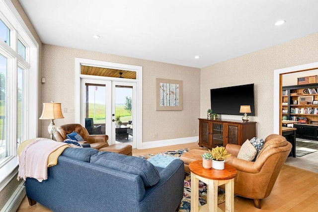 living area with light wood finished floors, baseboards, french doors, a baseboard heating unit, and recessed lighting