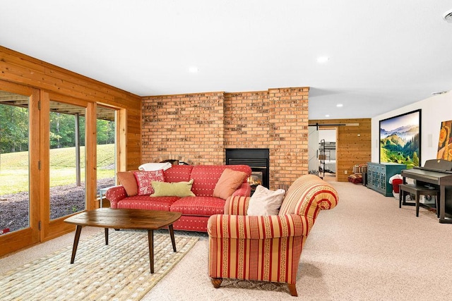 living room featuring carpet floors, recessed lighting, wooden walls, and a barn door