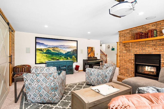 living area featuring a barn door, recessed lighting, carpet flooring, stairway, and a brick fireplace