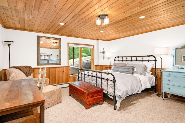 bedroom featuring a wainscoted wall, wood ceiling, baseboard heating, carpet floors, and wood walls